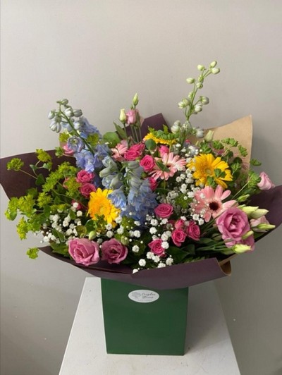 Mixed garden style bouquet to include blue delphiniums, cerise spray roses, pink Lisanthius, gypsophilium, daisies