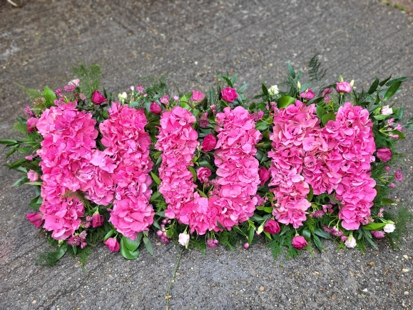 luxurious version of funeral letters based with hydrangea flower on bed of foliage. Made by florist from Croydon in South London, UK