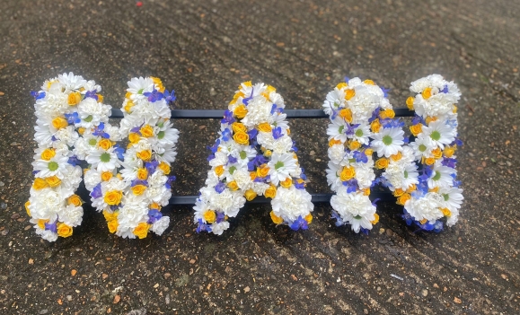 A delicate mix of white daisies, carnations with spray yellow roses and light blue delphiniums. by Croydon Blooms funeral florist Croydon