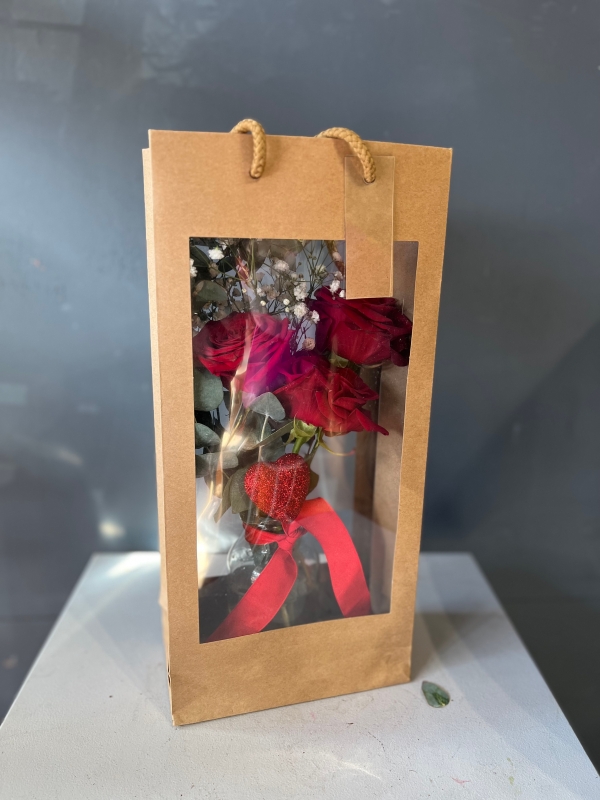 3 red roses and a heart in small vase presented in kraft gift bag.  Lovely additional gift for a young lady or as a token gift by florist in Croydon for delivery on Valentine’s Day 2023