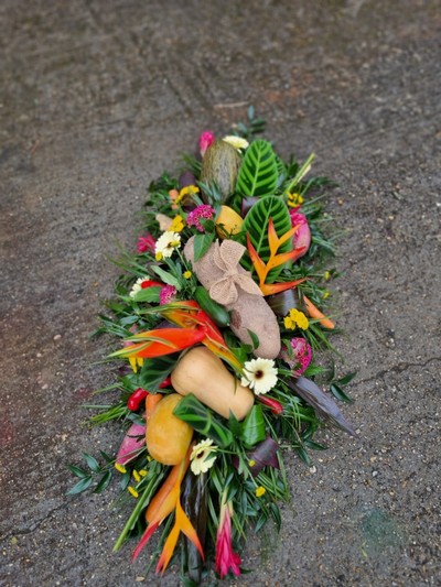 Caribbean funeral Coffin Spray with mixed tropical flowers and veggies done by florist in Croydon for free local delivery 