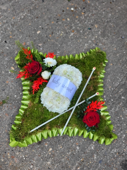 mossed funeral cushion with hobby related object by Croydon Blooms