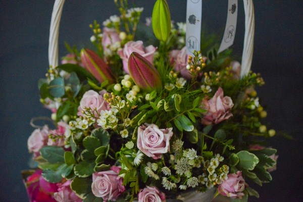 lovely arrangement of pink lilies and lilac roses in large 30cm white basket with exquisite Belgian Chocolates Box
