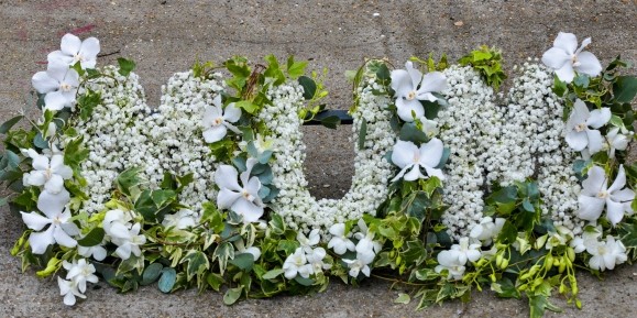 Luxury gypsophila letters decorated with orchids and trailing English ivy.  Designed by Best florist in Croydon, UK