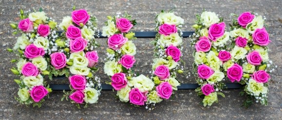 mixed pinks letters for a funeral by florist in CR