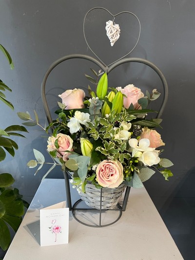 Stunning scented design with roses, freesias and lily arranged in wicker metal heart pot which can be reused as a porch planter. By florist in Croydon, Surrey, UK