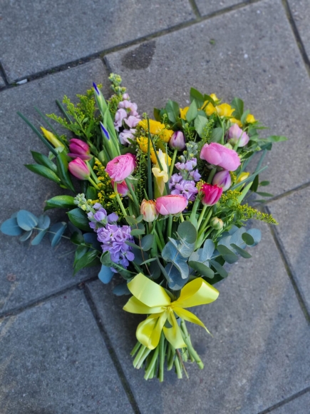 Mixed colours spring sheaf to include tulips, rununculus, stock, solidago, iris and eucalypthus. Please notice spring flowers are shorter and sheaf is petit. By Croydon Blooms Funeral Florist