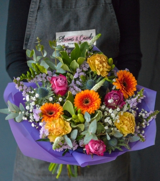 Bright flowers to include roses with foliage in a gift bag for delivery in Croydon, South London