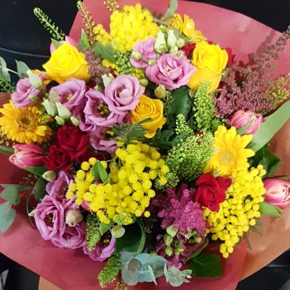spring bouquet to include mimosa, ranunculus, roses, grasses arranged by local florist in Croydon, CR0