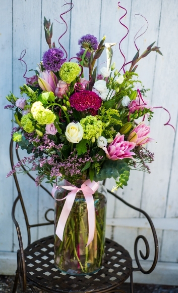 Beautiful arrangement of lovely flowers in large 30cm tall glass vase to include pink lily and viburnum arranged by florist in Croydon, South London, Surrey