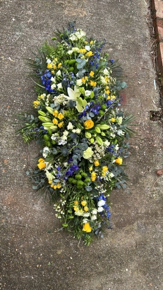 Coffin spray in blue, yellow, white and green suitable for a man made by florist in Croydon, Surrey 
