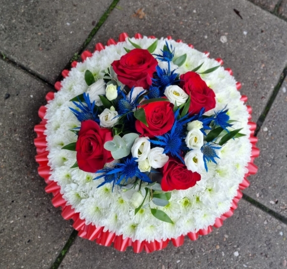 Traditionally based white posy with spray in red, blue and white. By Croydon Blooms Florist