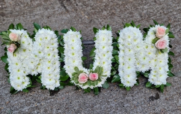 Classic letters but instead of plastic ribbon foliage green edges by Croydon Blooms florist